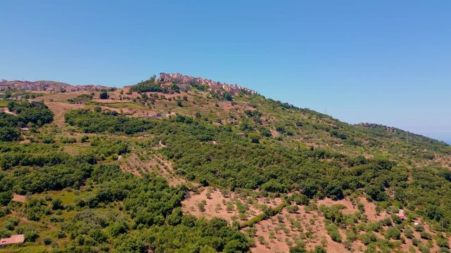 Cinematic aerial drone panorama of Tusa, Sicily. Historic hill town overlooking the Tyrrhenian coast with traditional Mediterranean architecture, scenic mountain landscape and panoramic views