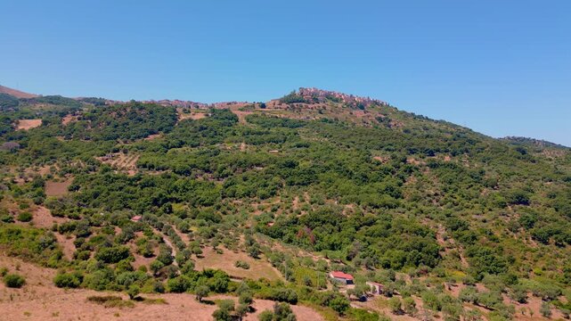 Cinematic aerial drone panorama of Tusa, Sicily. Historic hill town overlooking the Tyrrhenian coast with traditional Mediterranean architecture, scenic mountain landscape and panoramic views