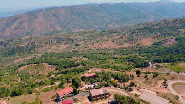 Cinematic aerial drone panorama of Tusa, Sicily. Historic hill town overlooking the Tyrrhenian coast with traditional Mediterranean architecture, scenic mountain landscape and panoramic views