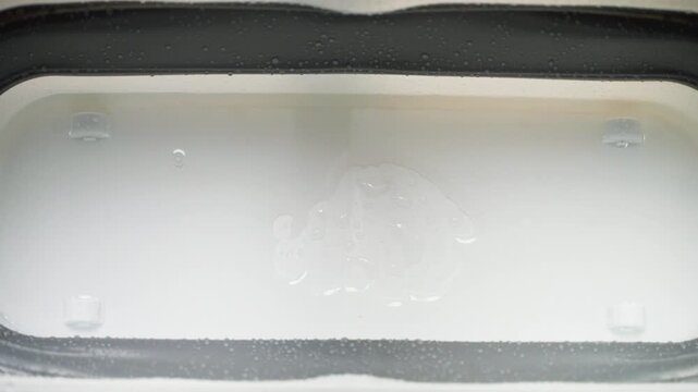 Water leaking from the ceiling dripping into a collection container.