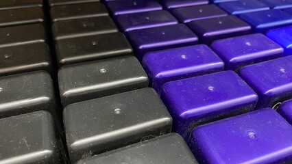 Obraz premium A close-up of a neatly arranged black and purple checkered pattern with dramatic lighting. This geometric plastic texture creates a modern, abstract, and futuristic feel.
