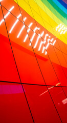 Close-up of a colorful wall made of glossy tiles in spectral colors with light reflections, representing diversity, creativity and modern architecture