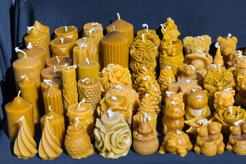 Naturalne świece z wosku pszczelego, ręcznie robione żółte świeczki o różnych kształtach, ekologiczna dekoracja i aromat miodu. © Henryk Guziak