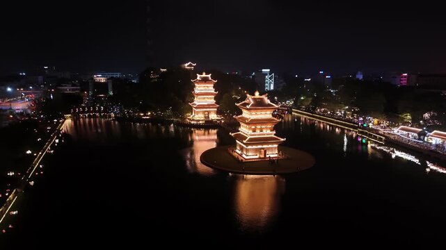 Aerial view of illuminated ancient hoa lu pagodas on the lake at night in ninh binh, vietnam