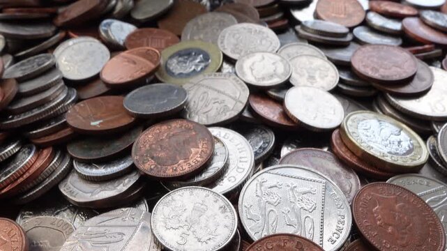 Slow camera movement over pile of coins seamless loop