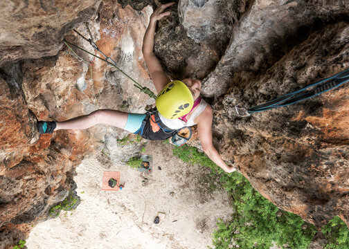 Thailand, Krabi, Lao liang island, woman climbing in rock wall