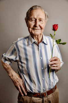 Portrait of smiling senior man with red rose