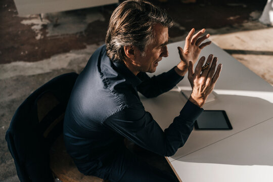Mature businessman talking at table in office