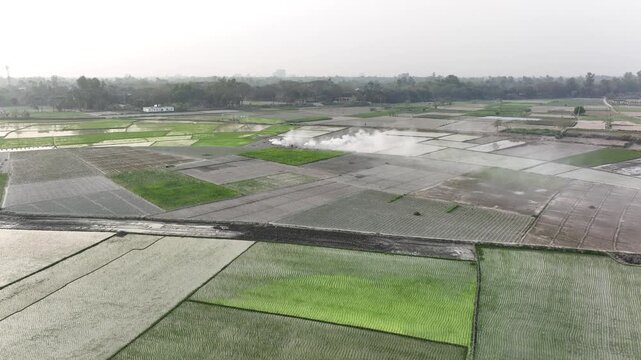 Agricultural workers fumigating crop fields aerial view
