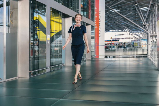 Portrait of smiling airline employee walking at the airport