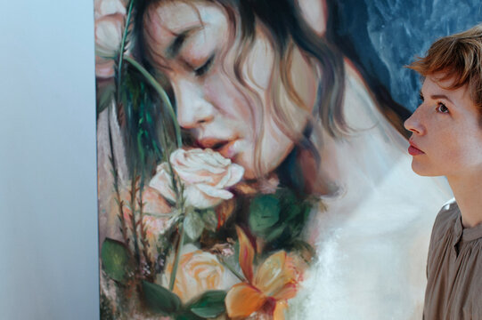 Thoughtful female artist by canvas painting in art studio