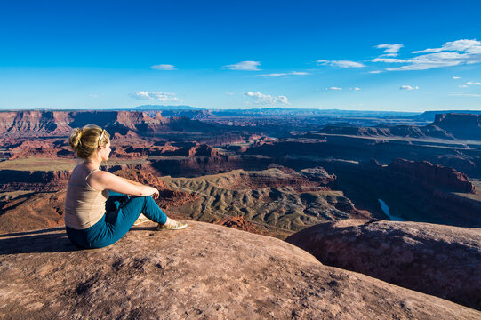 USA, Utah, Woman at a overlook over the canyonlands and the Colorado river from the Dead Horse State Park