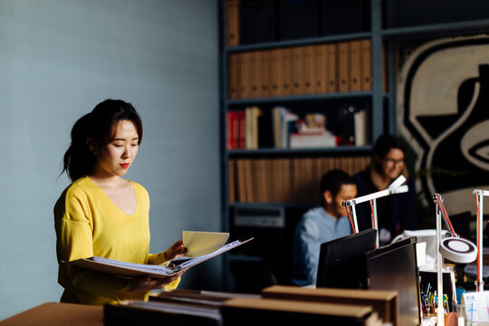 Young woman looking at files in office