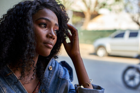 Portrait of young African woman in a cafe, looking out of window