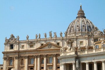 Obraz premium St. Peter's Basilica dome and facade in Vatican City under clear blue sky