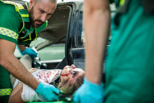 Paramedics moving car crash victim on stretcher
