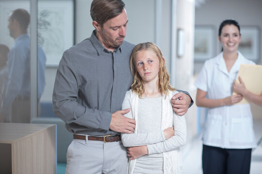Father guiding sick daughter in hospital