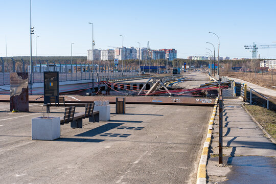 Irpin, Ukraine - 07 March 2026: View of the Irpin Bridge, scarred and broken, a stark reminder of conflict against a backdrop of clear skies and distant buildings.