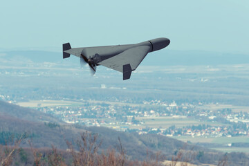 Naklejka premium Kamikaze attack drone flies above rural landscape during war.