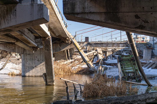 Irpin, Ukraine - 07 March 2026: View of a shattered bridge over water, its concrete form contrasting with the cold, reflective surface below.