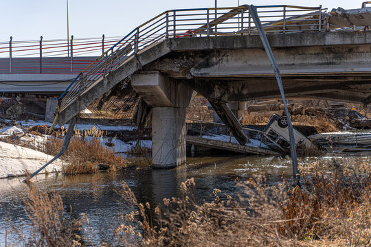 Irpin, Ukraine - 07 March 2026: View of the Irpin Bridge, where shattered concrete and twisted metal plunge into the water, a stark reminder of destruction.