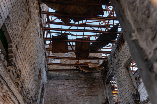 Irpin, Ukraine - 07 March 2026: View of a building at 31 Universitetska Street, its roof torn away, revealing the sky through jagged metal and fractured beams.