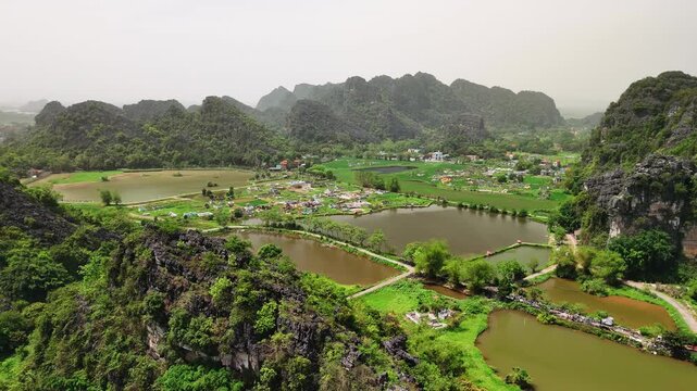 Aerial view of hoa lu ancient capital in ninh binh, with lush rice paddies, lakes, and towering karst mountains