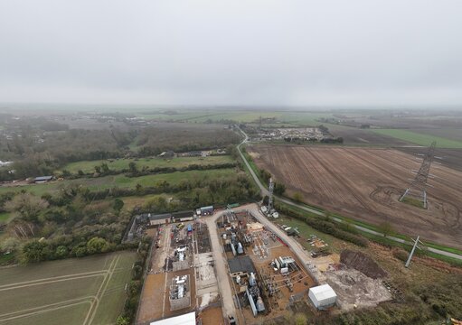 Aerial view of a substation surrounded by fields and trees under a pale sky, Burwell, United Kingdom.