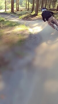 Kids having fun driving downhill MTB mountainbike on sunny day - vertical video