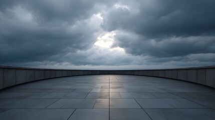 Obraz premium A curved modern terrace paved with large tiles overlooking a calm horizon under a dramatic luminous cloudy sky