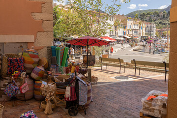 Cassis, France, September 09 2024 Colorful Basket Market Stall in Mediterranean Coastal Town Harbor With Waterfront Promenade and Caf&eacute;s