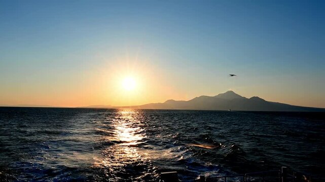 光の航路。沈みゆく太陽と、静かなる火山の記憶。
「夕日に照らされる有明海と雲仙・普賢岳のシルエット。島原港から熊本港へ向かうフェリーの航跡と黄昏の絶景。」
A path of light. The setting sun and the memory of a quiet volcano.