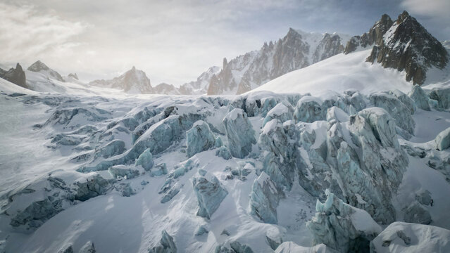 Aerial view of the stark, icy expanse of Vallee Blanche Glacier contrasting against the towering, snow-dusted peaks, Chamonix-Mont-Blanc, Auvergne-Rhone-Alpes, France.