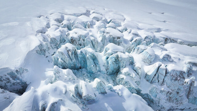 Aerial view of sun-kissed glacial ice formations sculpt a breathtaking landscape across Vallee Blanche Glacier, Chamonix-Mont-Blanc, Auvergne-Rhone-Alpes, France.