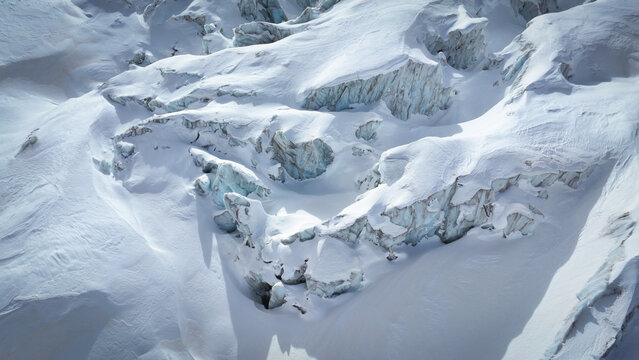 Aerial view of the stark, icy Vallee Blanche Glacier, its crevasses and snowdrifts a tapestry of white and blue, under the crisp mountain air, Chamonix-Mont-Blanc, Auvergne-Rhone-Alpes, France.