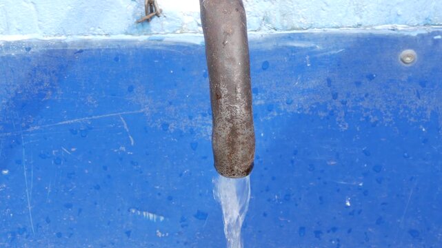 Water flowing from an old rusty pipe