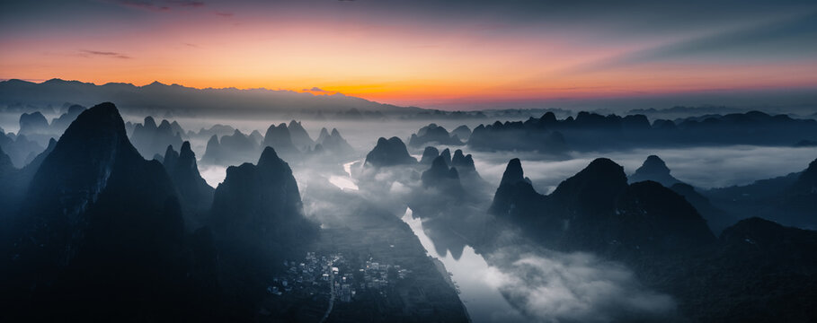 Aerial view of karst mountains piercing through a sea of mist during sunrise, Guilin, Guangxi, China.