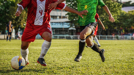 Professional soccer match at golden hour, focus on player's legs and the ball