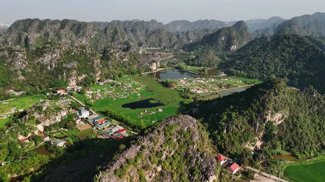 Aerial view of hoa lu valley with karst mountains, green rice fields, and river, in ninh binh province, vietnam