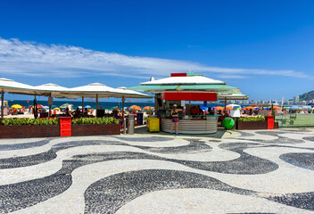 View of Copacabana beach and Leme beach with tables of kiosk and mosaic of sidewalk in Rio de Janeiro, Brazil. Copacabana beach is the most famous beach in Rio de Janeiro. 