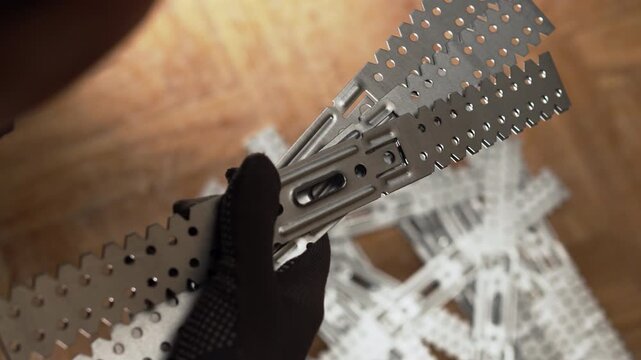 Female hands holding Front view of metal universal drywall bracket