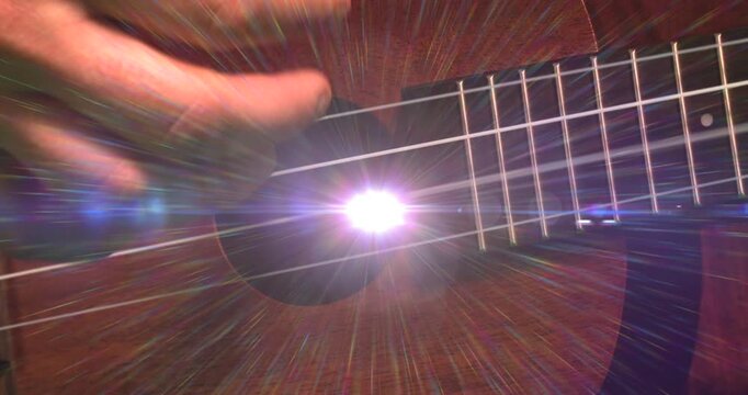 Animation of light flashing over hand of caucasian man playing guitar