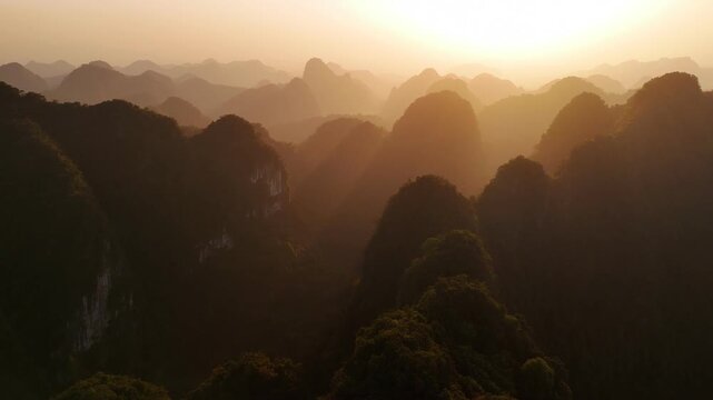 Golden sun rays shining over mountains and jungle in ninh binh, vietnam at sunsete
