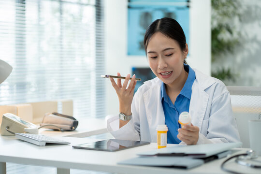 Asian female doctor using a smartphone in a hospital,interacting with a virtual assistant or AI chatbot.doctor reviews health data via ai agent,smart mirror technology,future technology