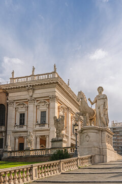 Capitoline Hill's Cordonata staircase leading to Piazza del Campidoglio, featuring the ancient Roman statue of Castor with his horse and historical architecture under a cloudy sky