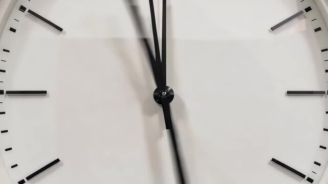 A close-up video of a clock face with black hands and markers on a white background showing the passage of time