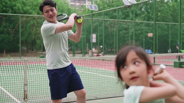 Happy family enjoying a lively game of tennis