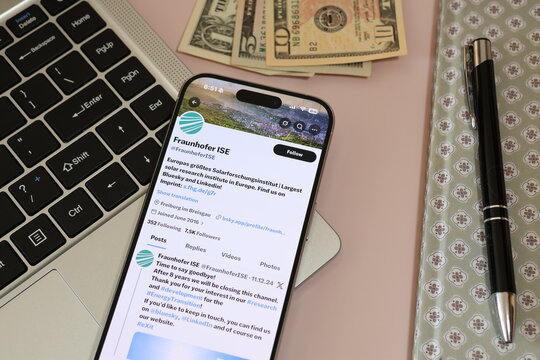 Kiel, Germany - 03-10-2026: X (Twitter) Profile of German solar research institute Fraunhofer ISE displayed on smartphone lying on a laptop keyboard