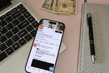 Fototapeta premium Kiel, Germany - 03-10-2026: X (Twitter) Profile of Danish toy company LEGO displayed on smartphone lying on a laptop keyboard