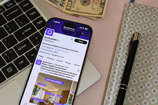 Kiel, Germany - 03-10-2026: X (Twitter) Profile of US semiconductor company Qualcomm displayed on smartphone lying on a laptop keyboard
